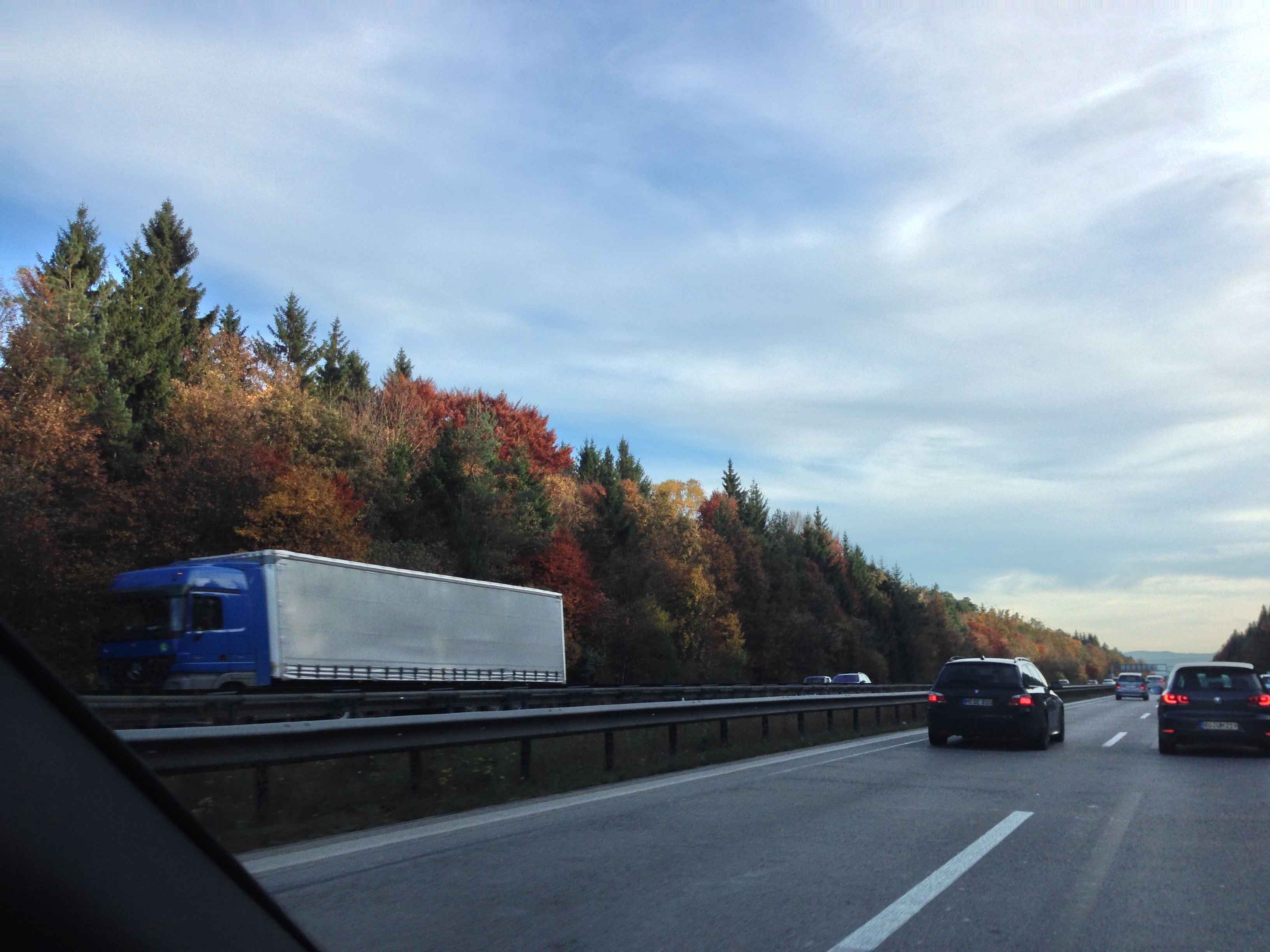 a car driving on a highway with trees in the background