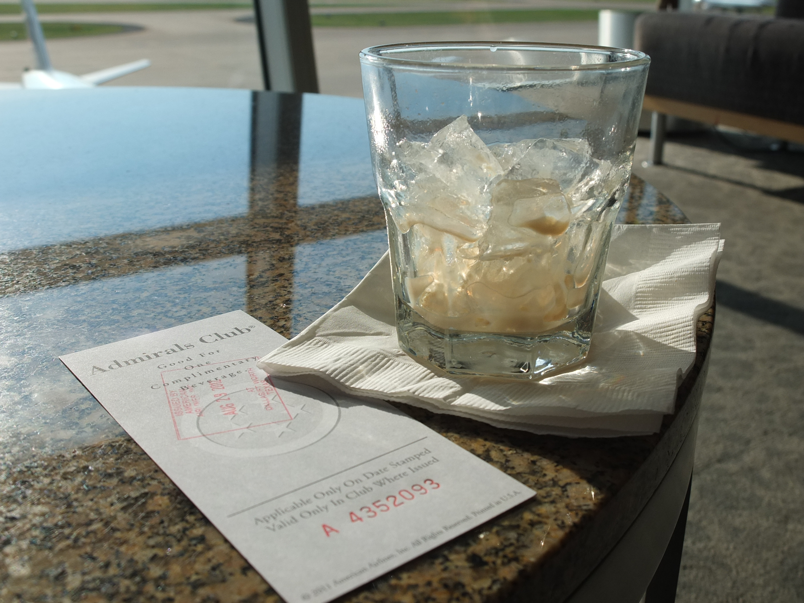 a glass of ice cubes on a napkin on a table