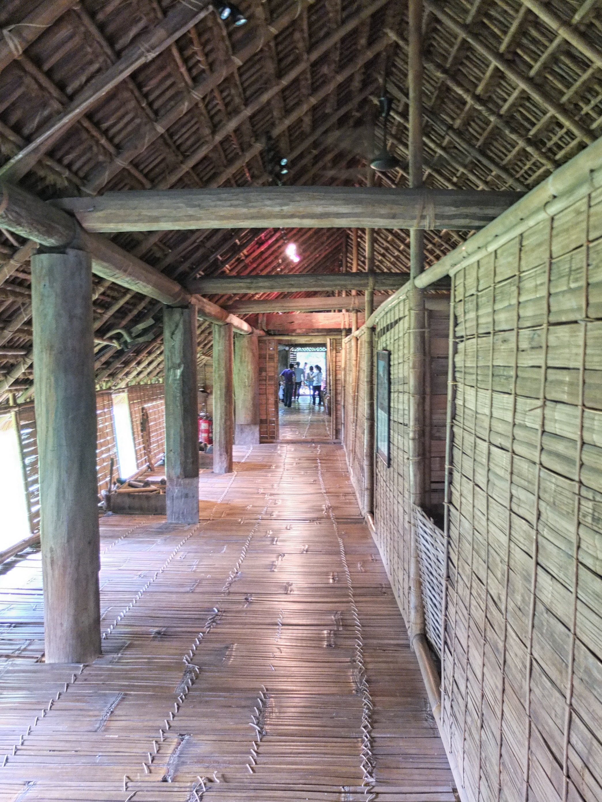 a long wooden hallway with people walking in the background
