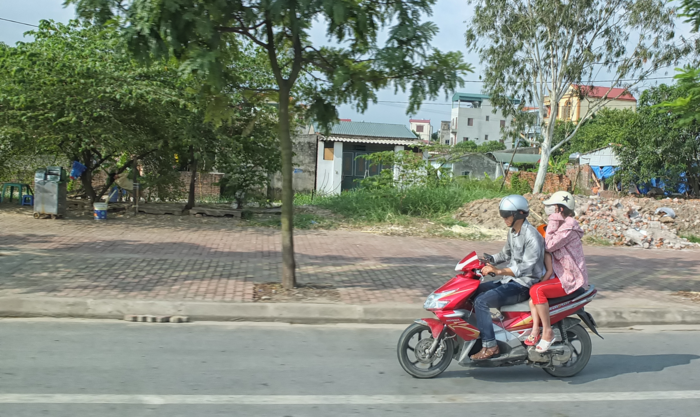 Family on a scooter (notice the kid wedged in between the parents)