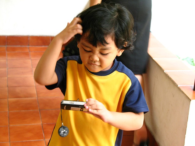 a young boy holding a cell phone