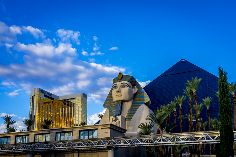 a large statue of a sphinx and a pyramid with Luxor Las Vegas in the background