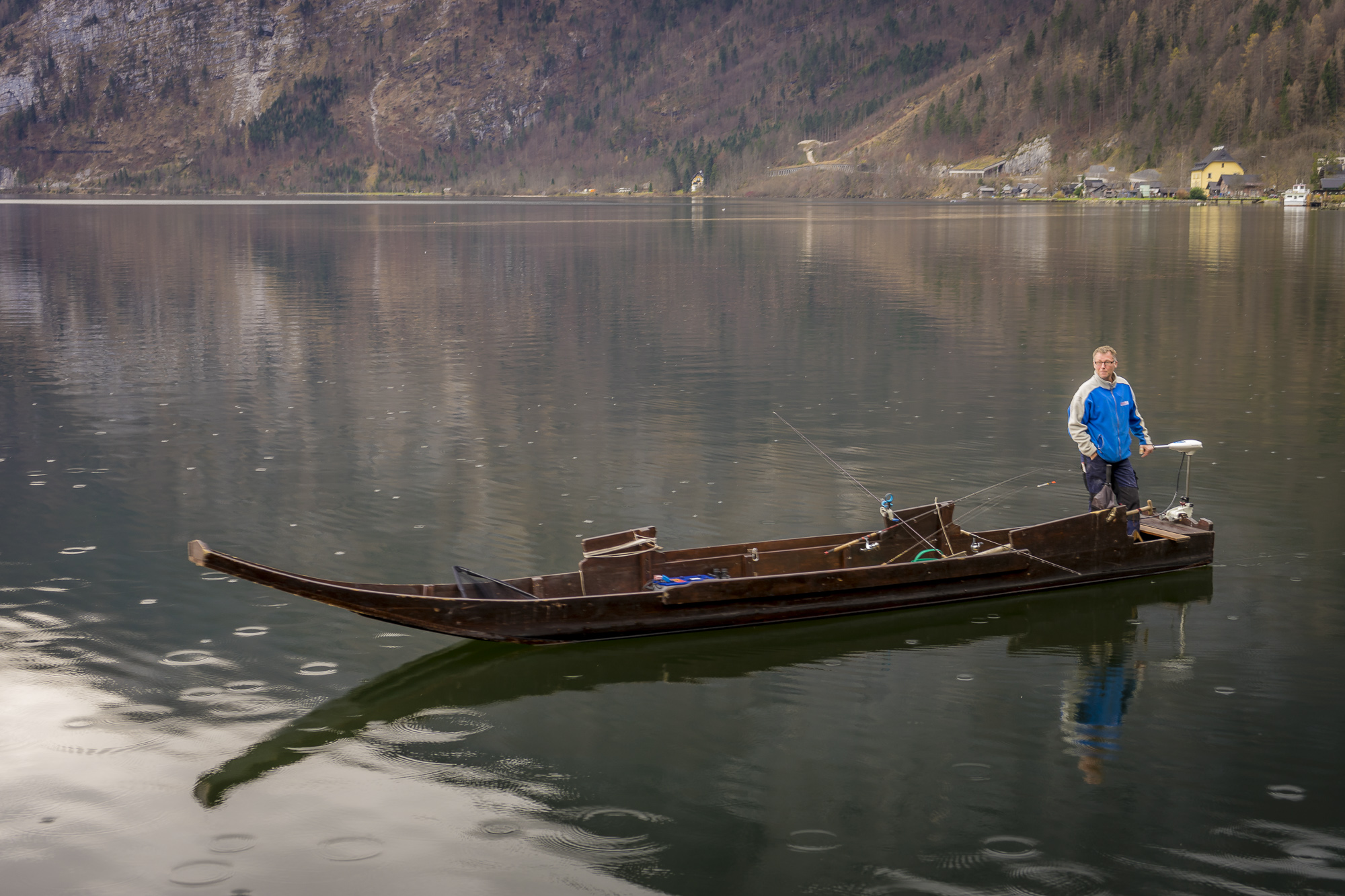 a man standing on a boat in a lake