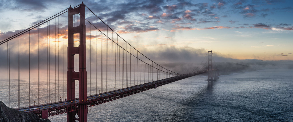 Golden Gate Bridge over water with clouds and fog