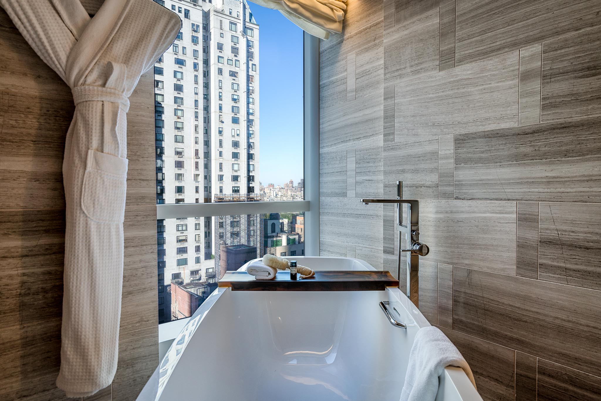a bathtub in a bathroom with a window overlooking a city