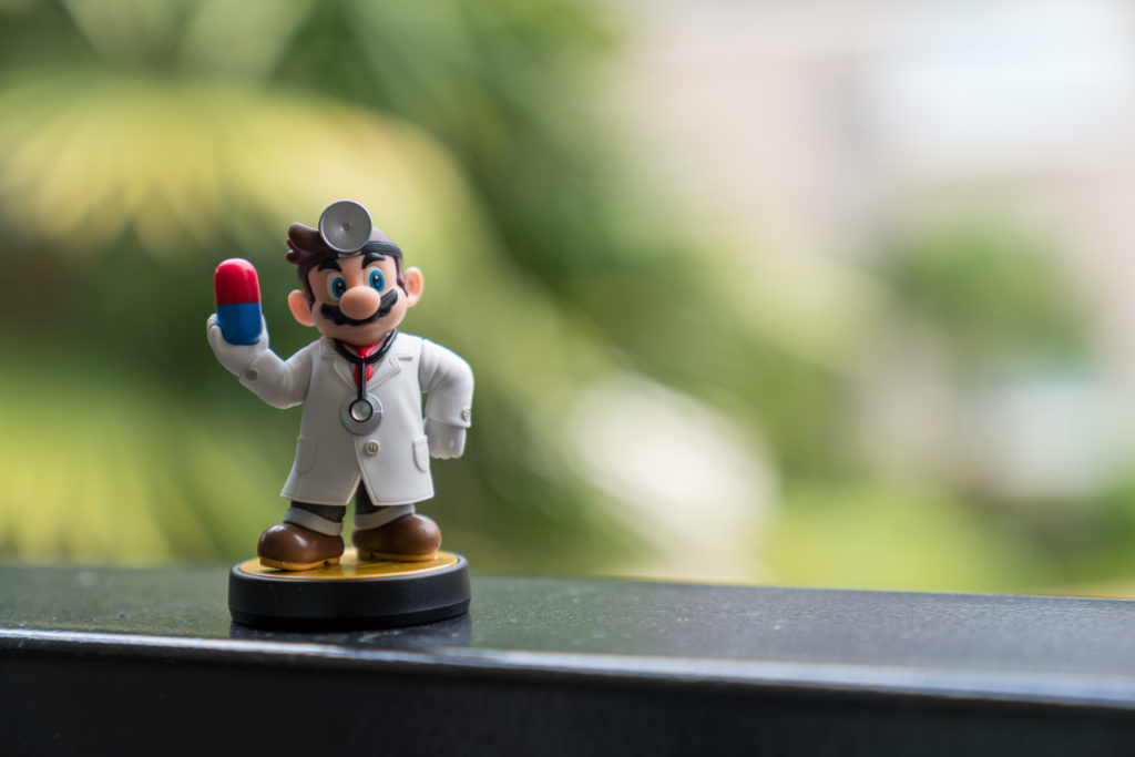 a toy doctor holding a pill
