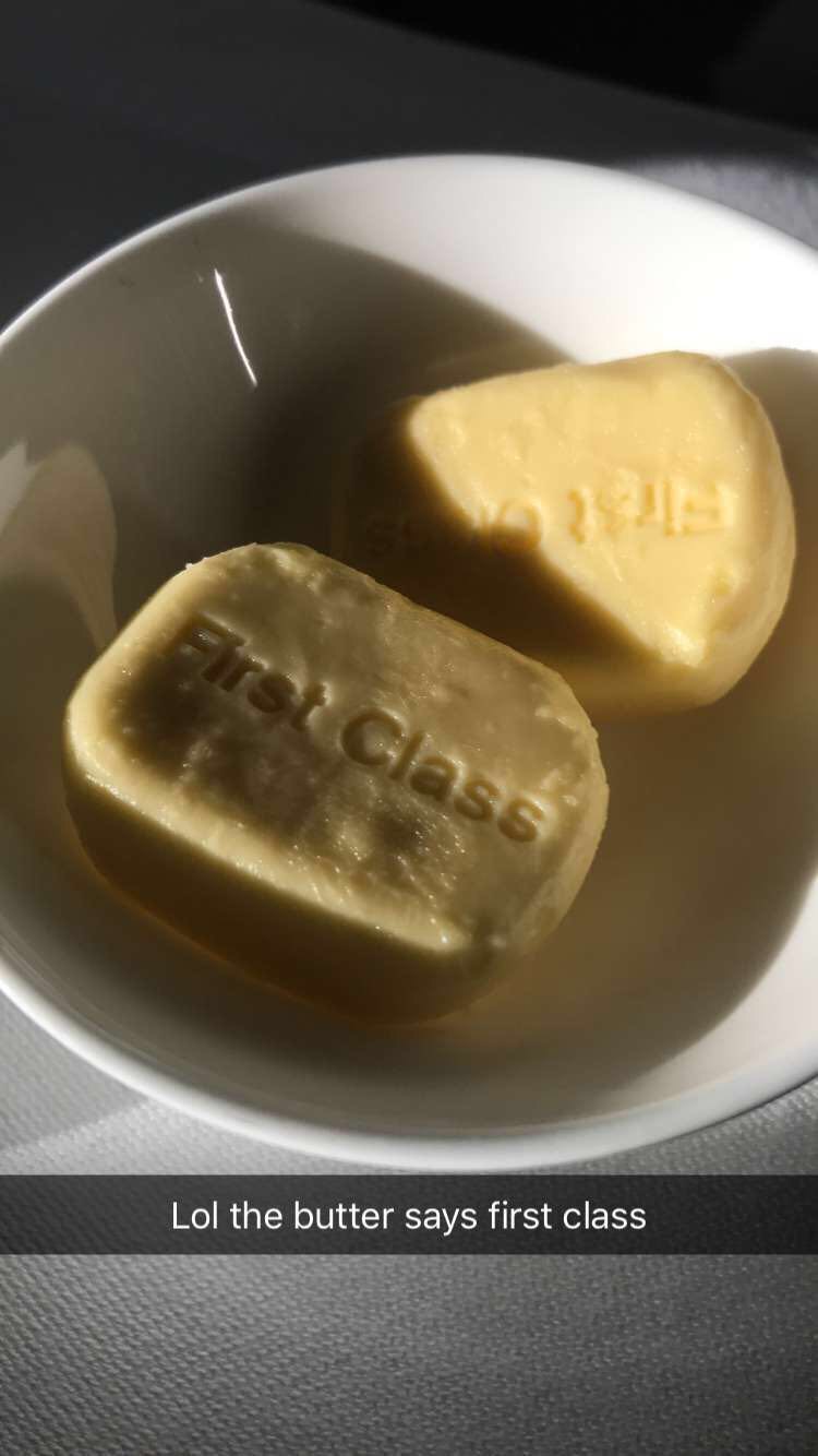 a white bowl with two pieces of butter