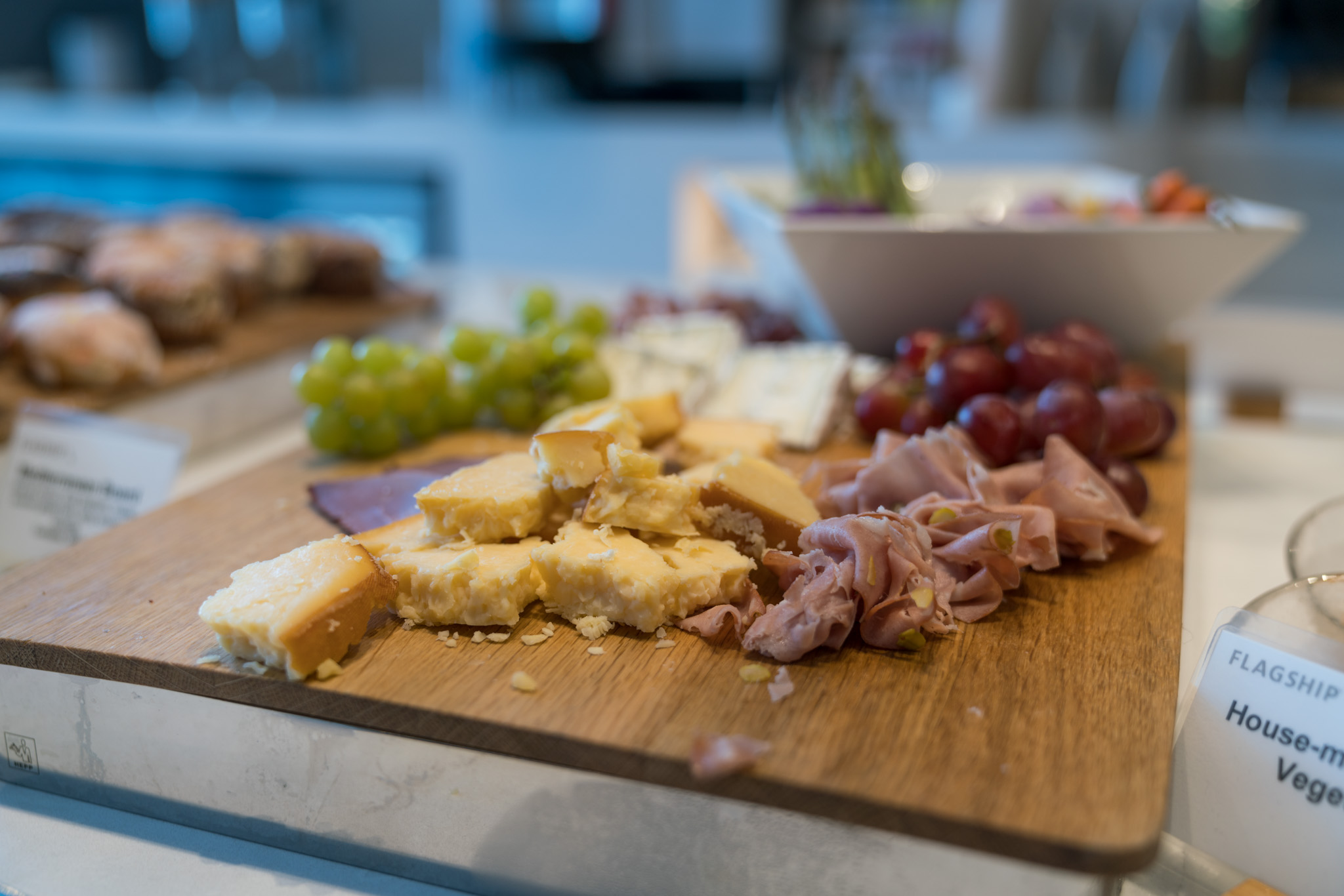 a cutting board with cheese and grapes