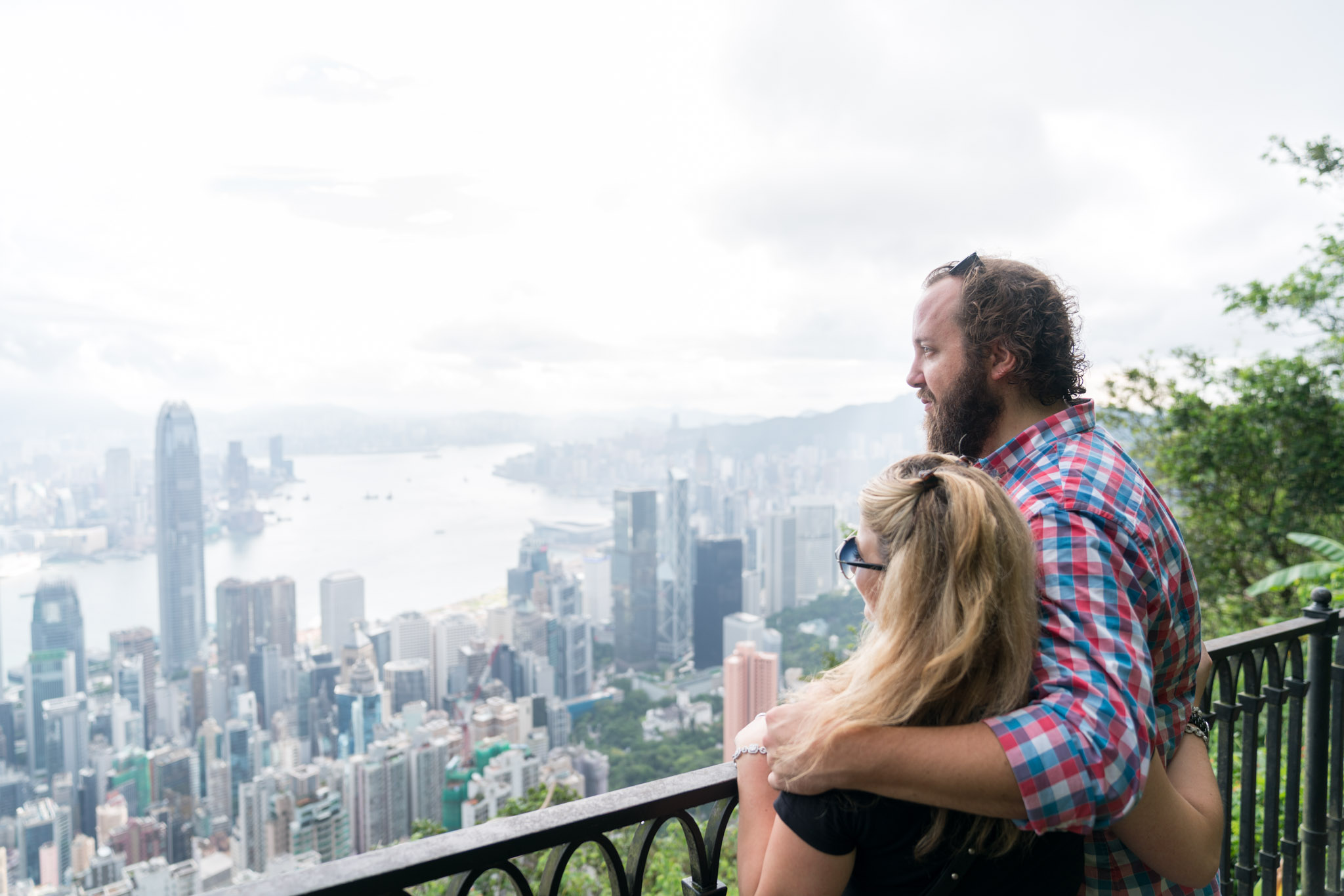 a man and woman sitting on a balcony overlooking a city