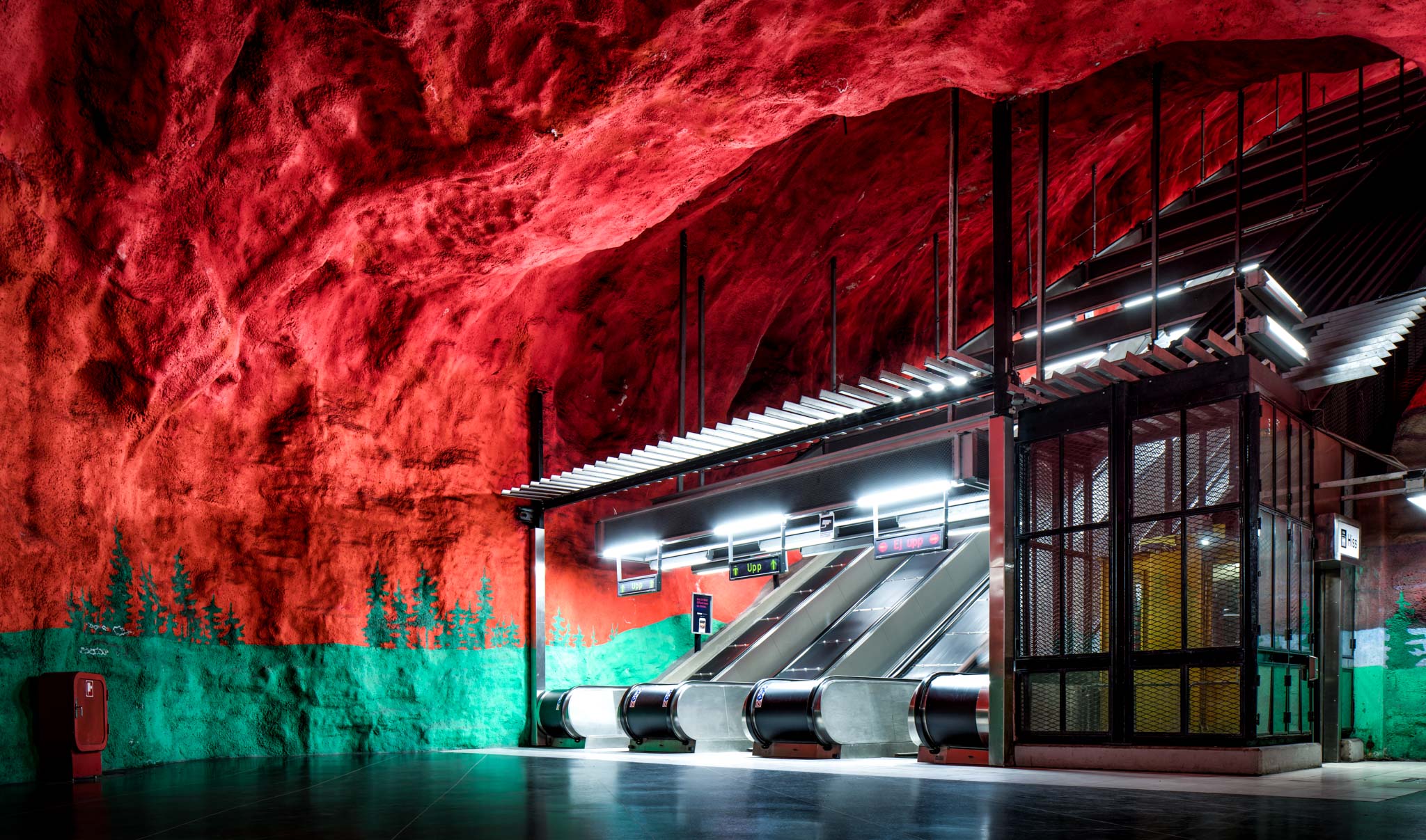 a red and green painted wall with escalators