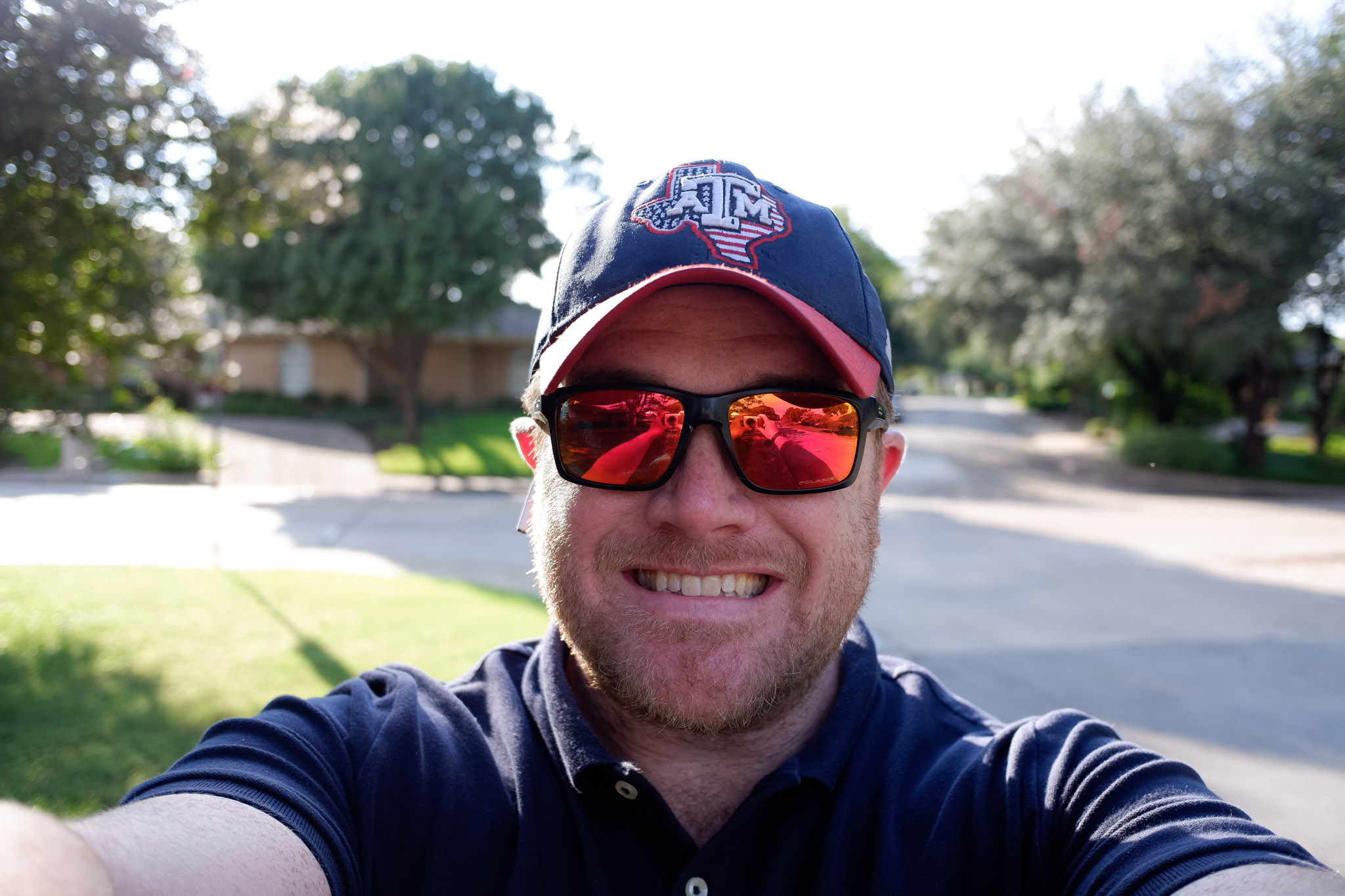 a man wearing sunglasses and a baseball cap taking a selfie