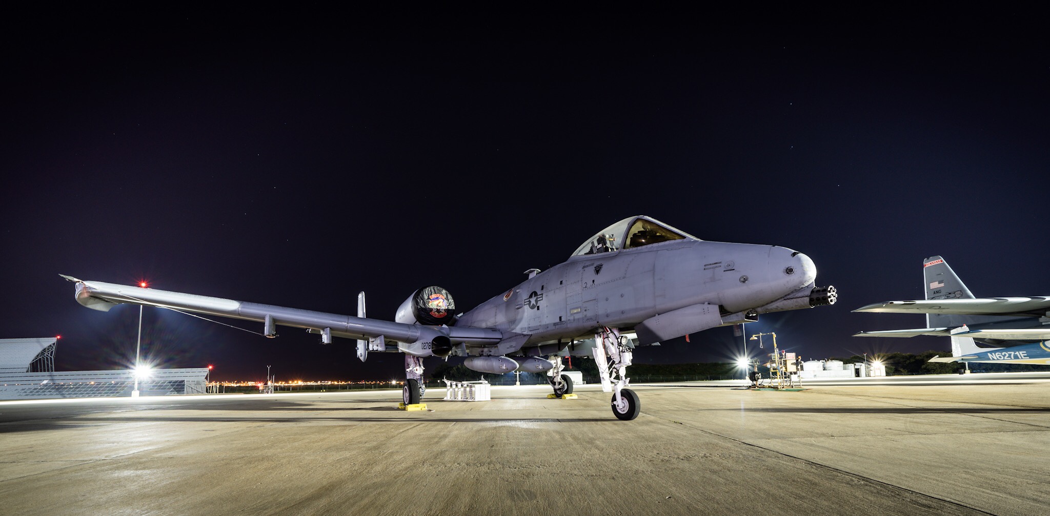 a military jet on a runway at night