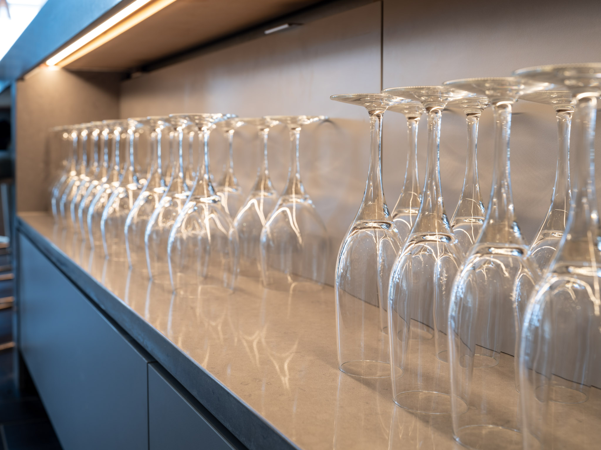 a row of wine glasses on a counter