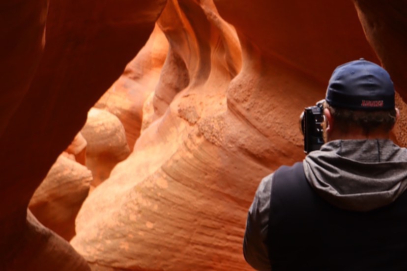 a man taking a picture of a canyon