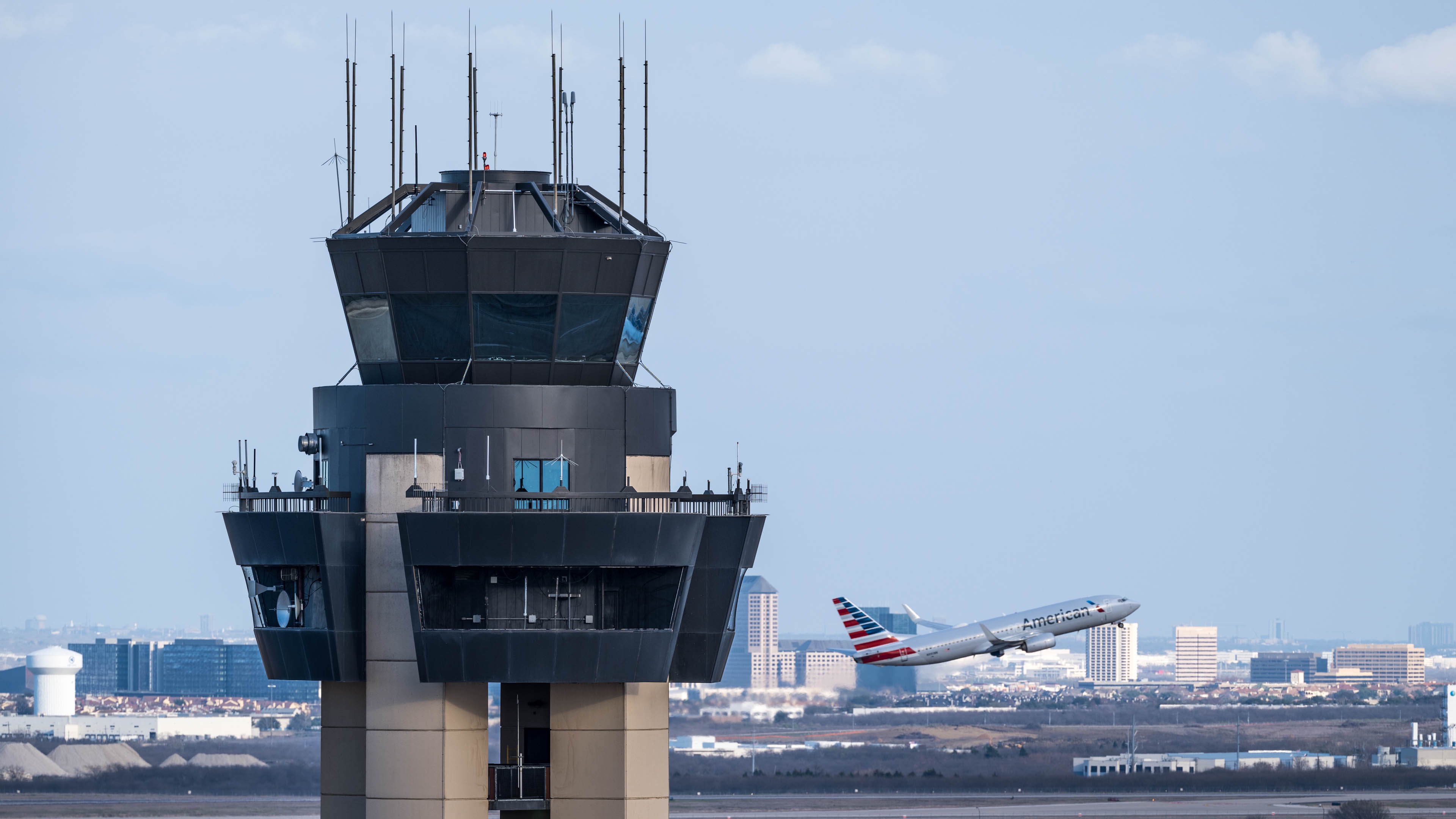 a plane flying over a control tower