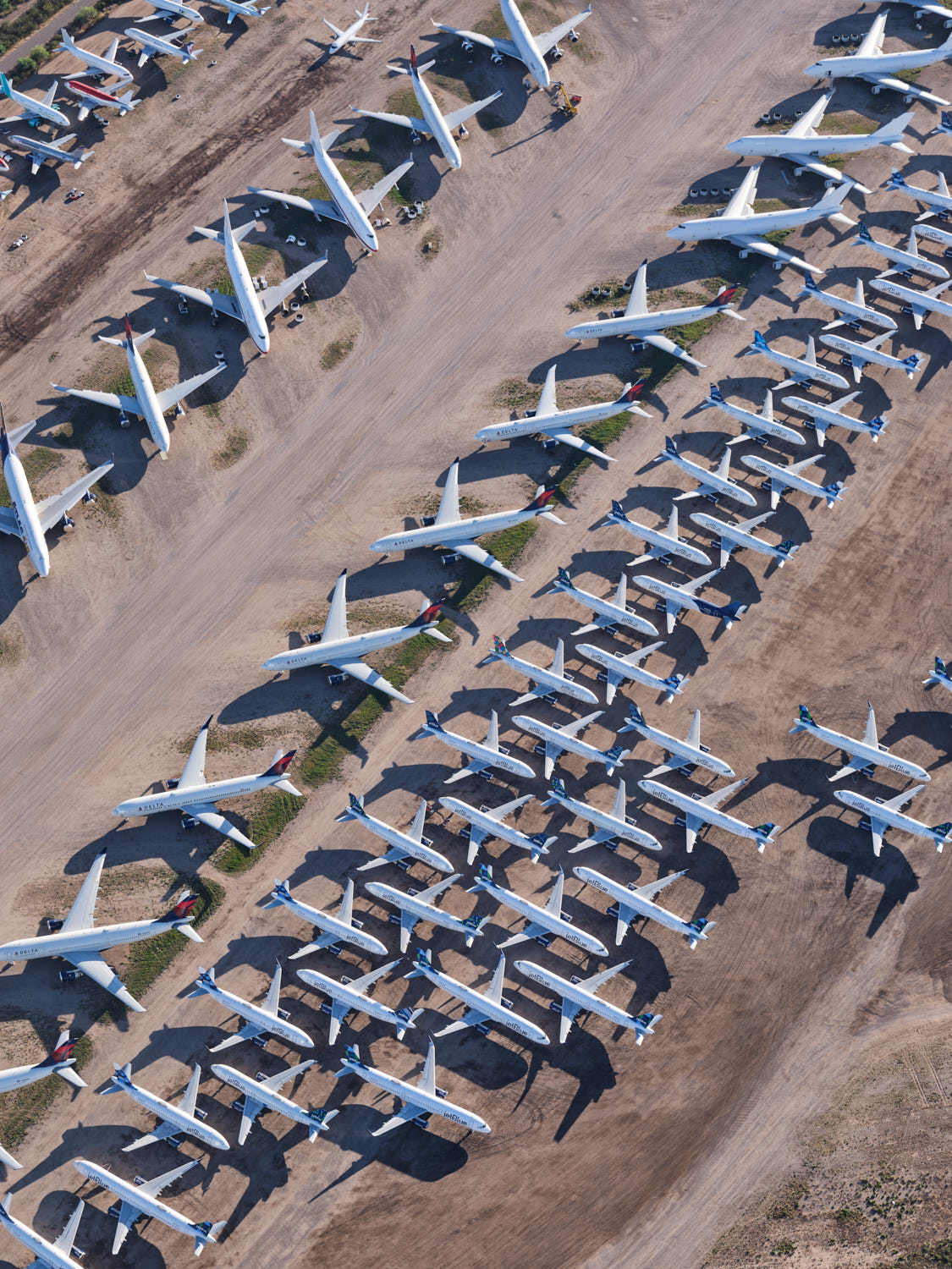 an aerial view of airplanes parked on dirt