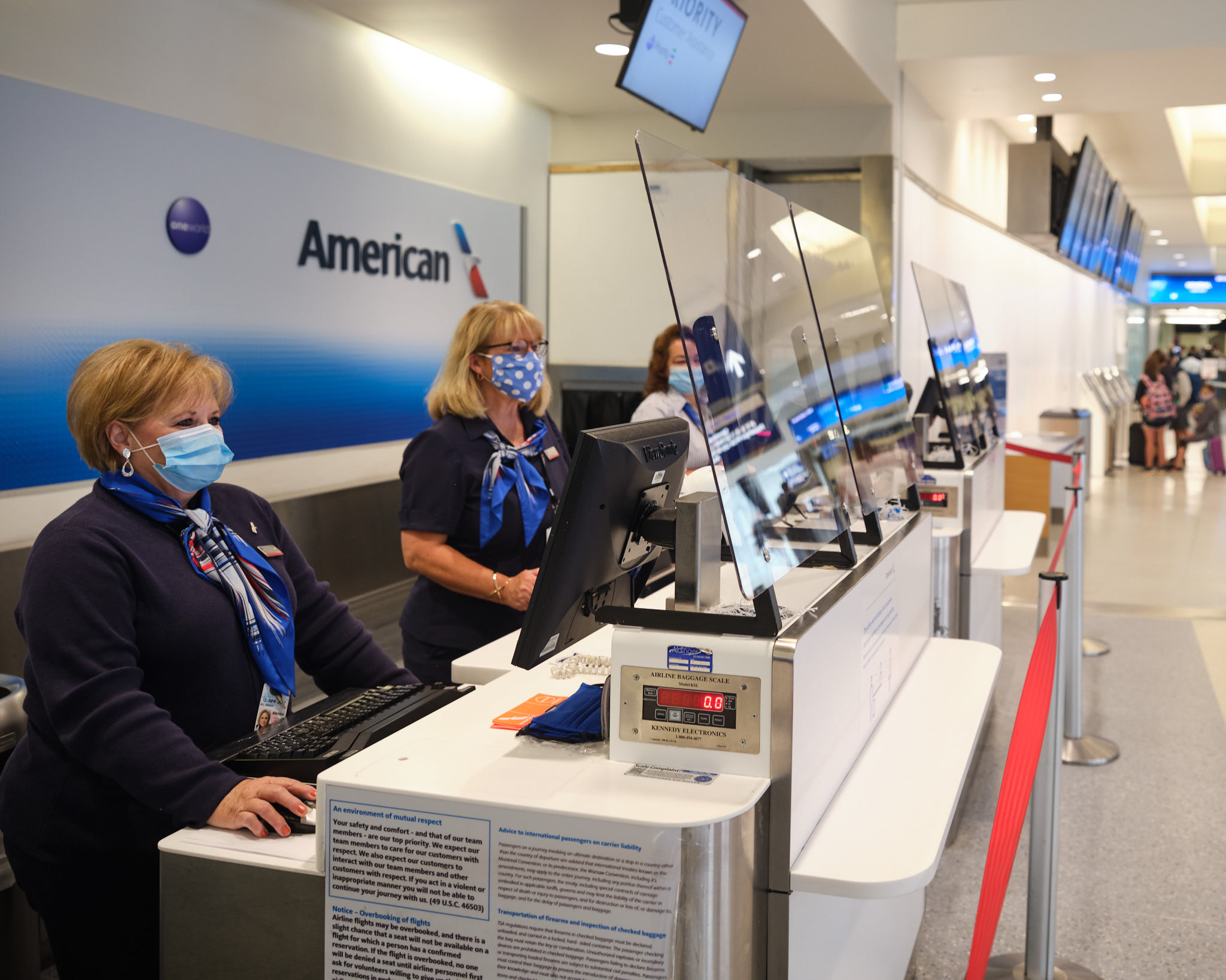 a group of people wearing face masks at a check-in counter